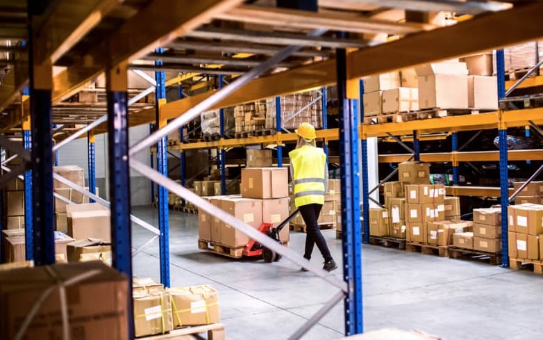 Moving boxes with pallet jack inside warehouse
